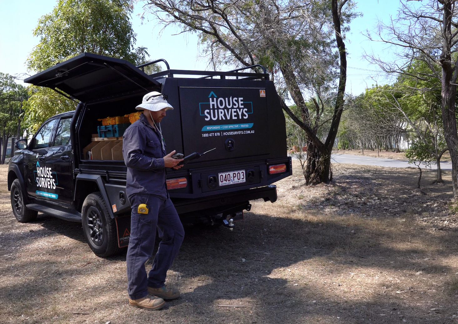 Professional surveyor conducting a topographical survey of a coastal roadside area.
