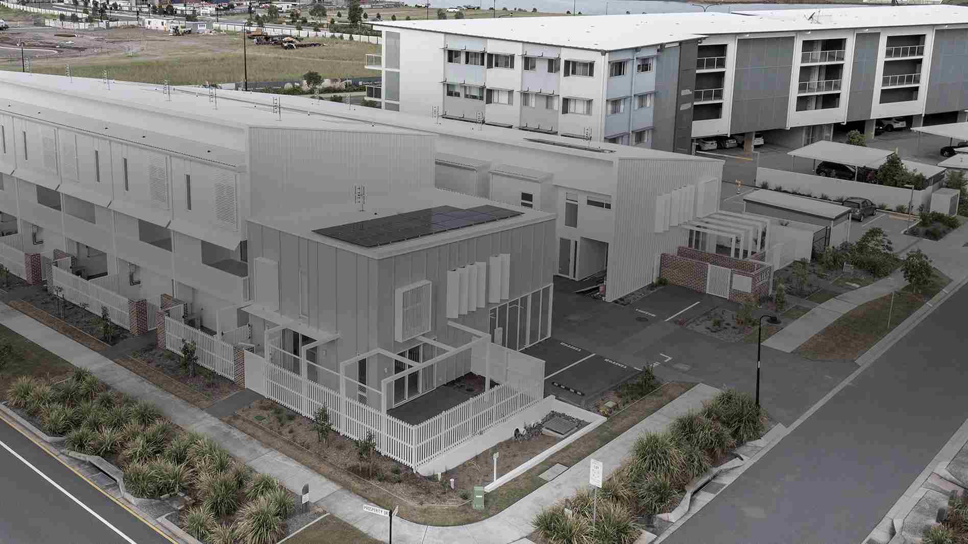 Modern white residential building viewed from above, showcasing property layout and structure for House Surveys